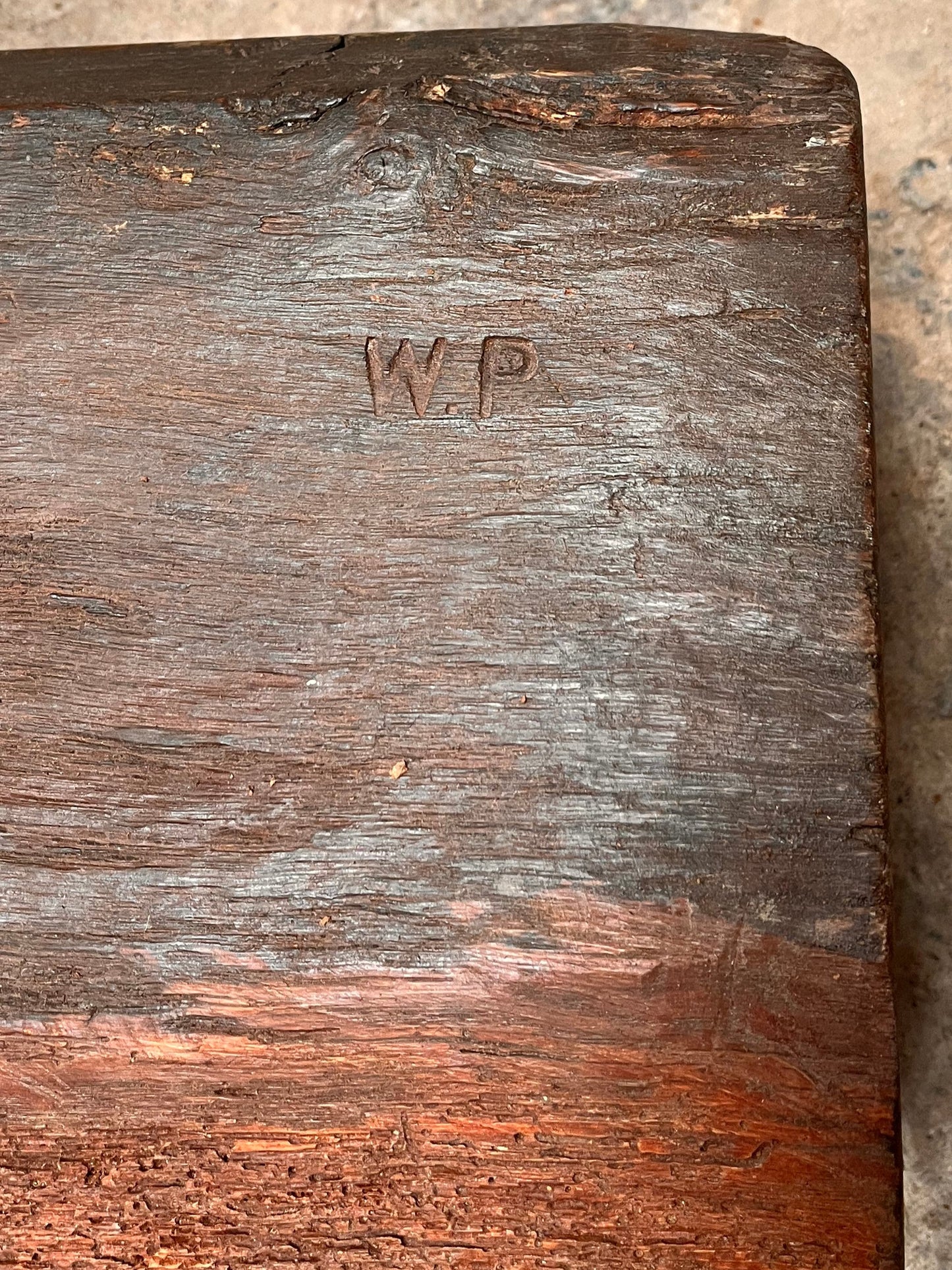 Wooden block with 'W.P.' branding on a stone surface