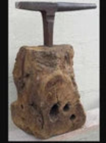 Antique Tinsmiths stake anvil leaded into a large section of tree trunk quirky coffee table idea
