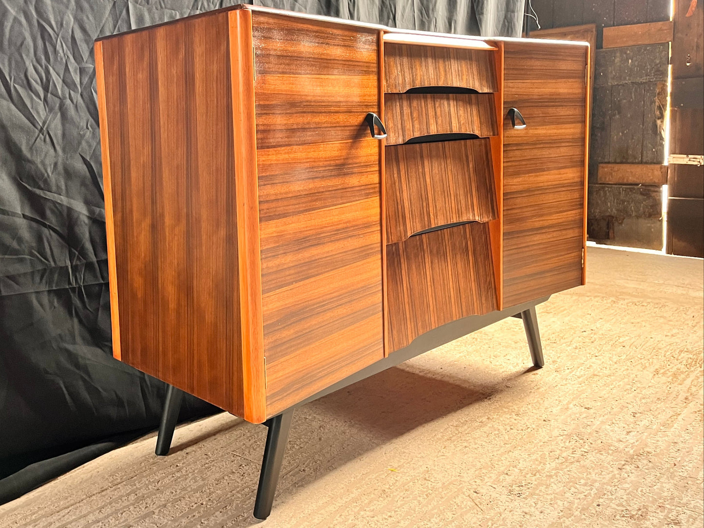 Wooden sideboard with a black backdrop