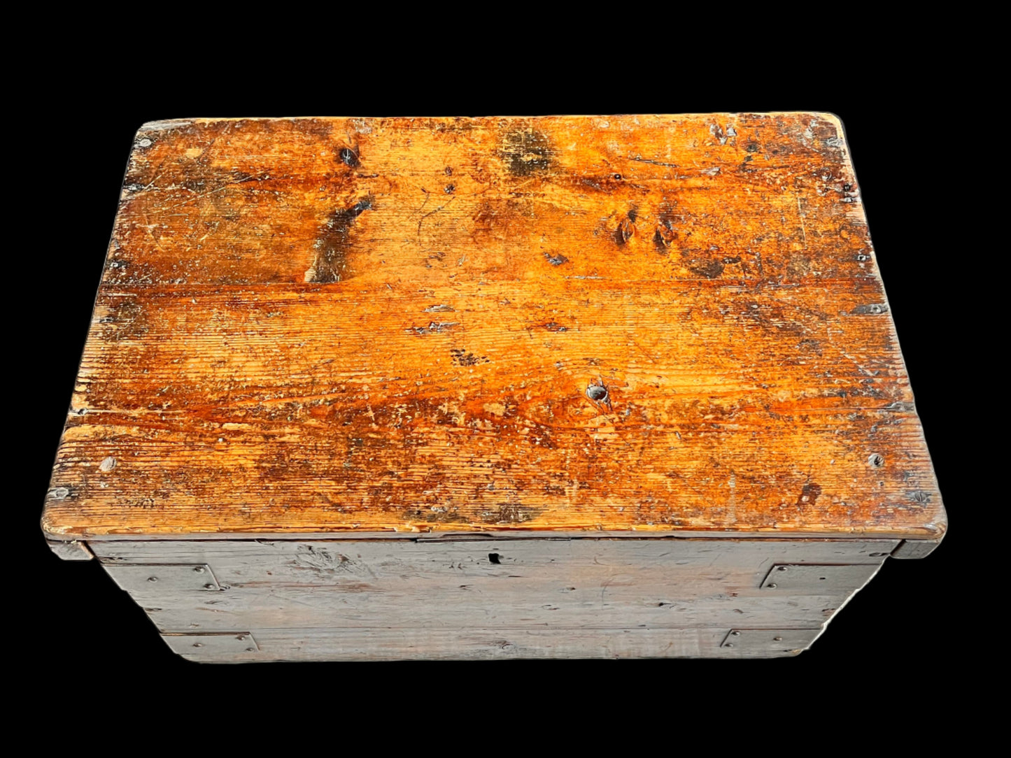 Worn wooden crate on a concrete surface with a dark fabric background