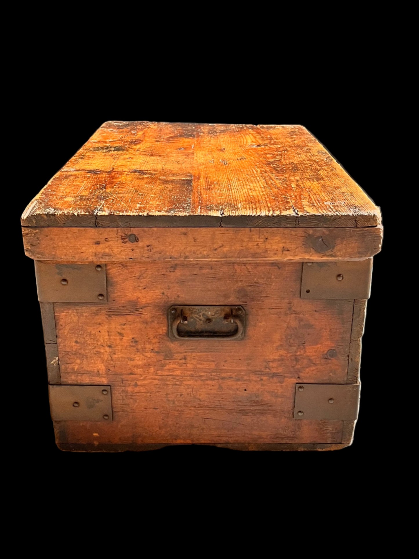 Vintage wooden trunk against a textured wall and black fabric background