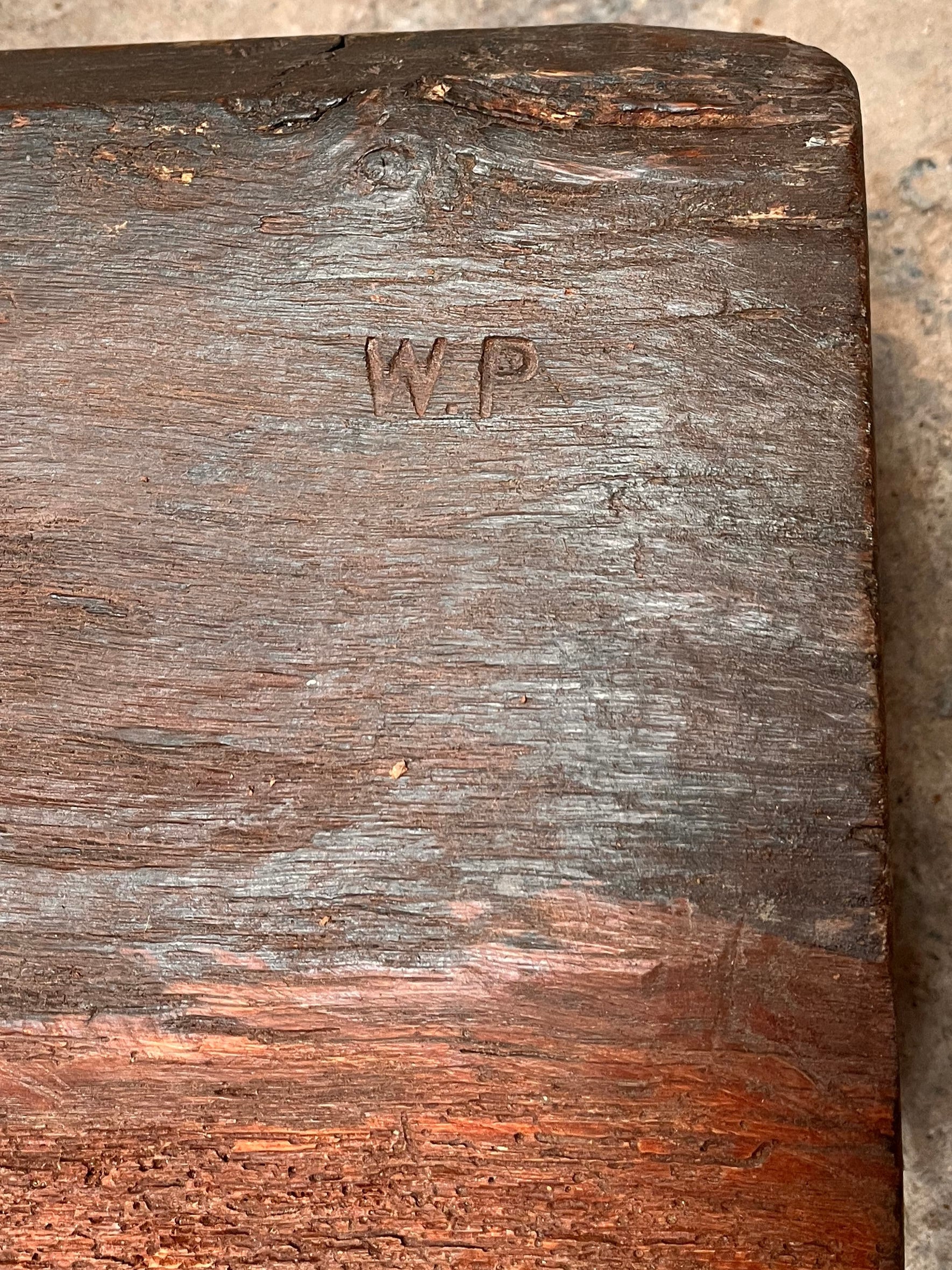 Wooden block with 'W.P.' branding on a stone surface