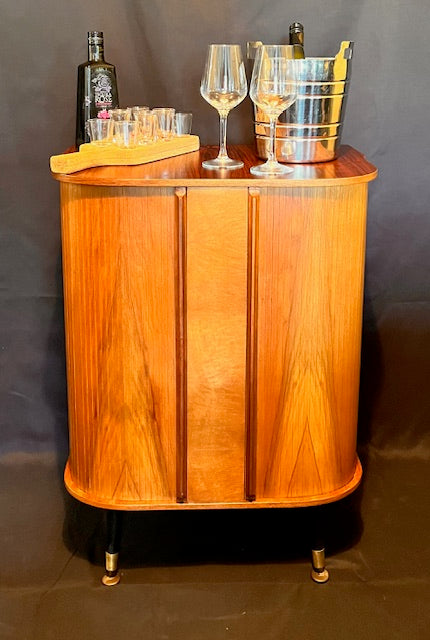 Mid Century Bow Fronted 'Sureline' Cocktail Drinks Cabinet In Walnut By George Serlin With Tambour Sliding Doors On Splayed Atomic Legs